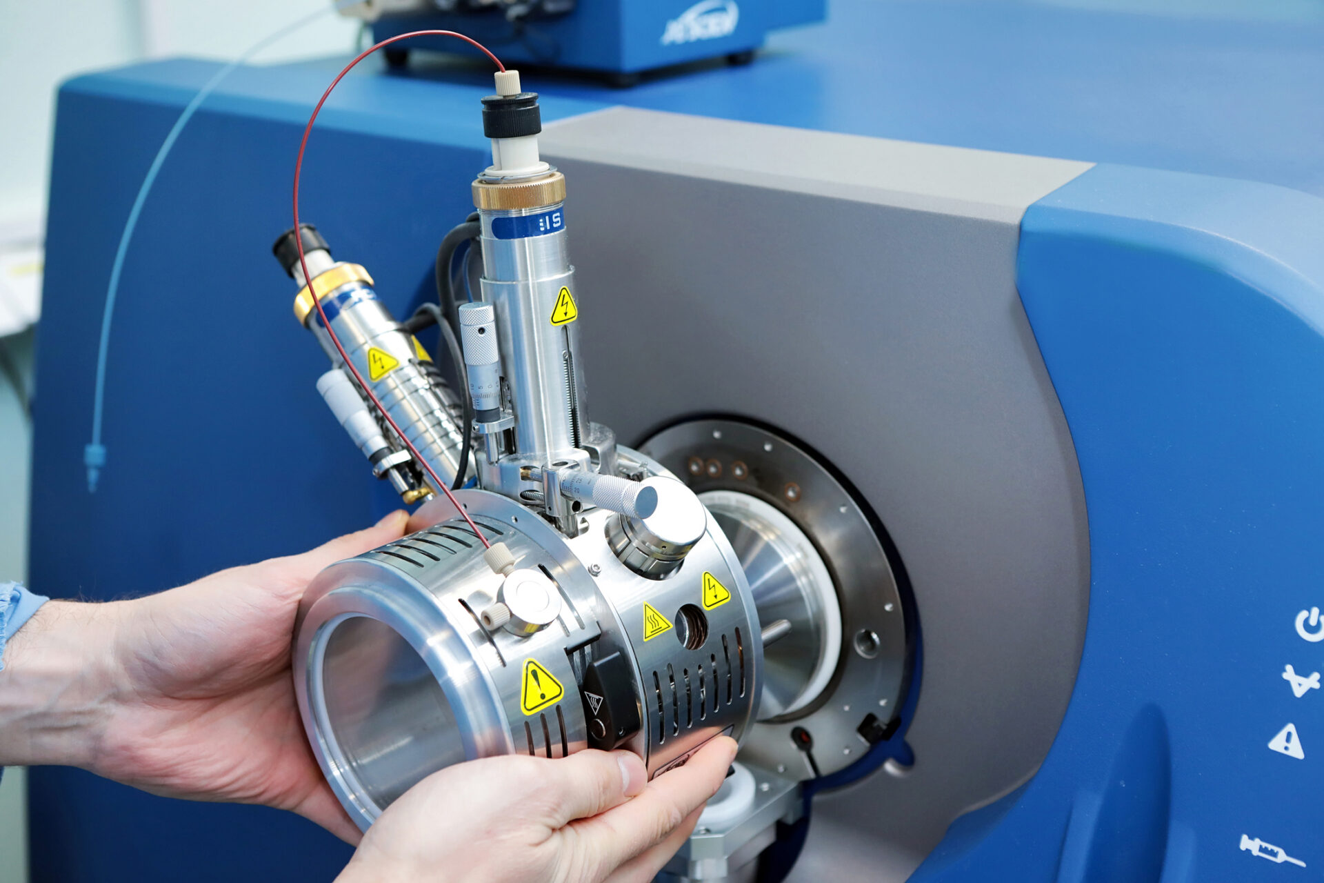 Adjust the mass spectrometer. The man analyzes the device for determining the masses of atoms. Device for the pharmaceutical industry. Ionic source of mass spectrometer