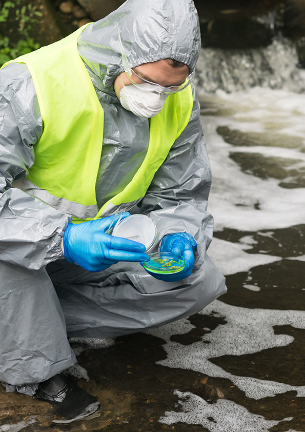 A man in a protective suit holds a Petri dish with a sample for plants